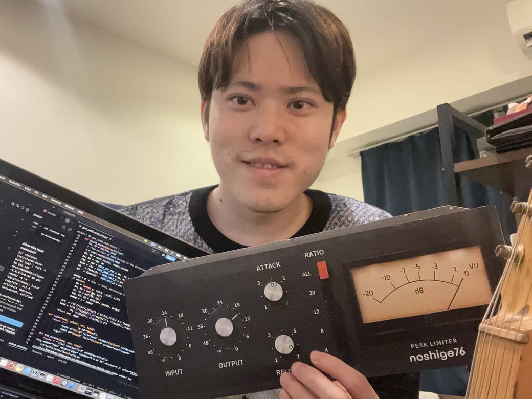 Souta Tano at his desk, holding the noshige76 panel next to his laptop