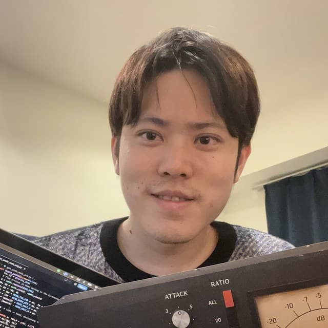 Souta Tano at his desk, holding the noshige76 panel next to his laptop